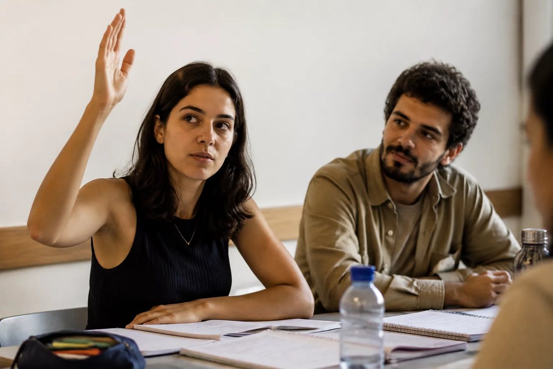 Facilitador em pé apontando para um argumento escrito no quadro durante a sessão